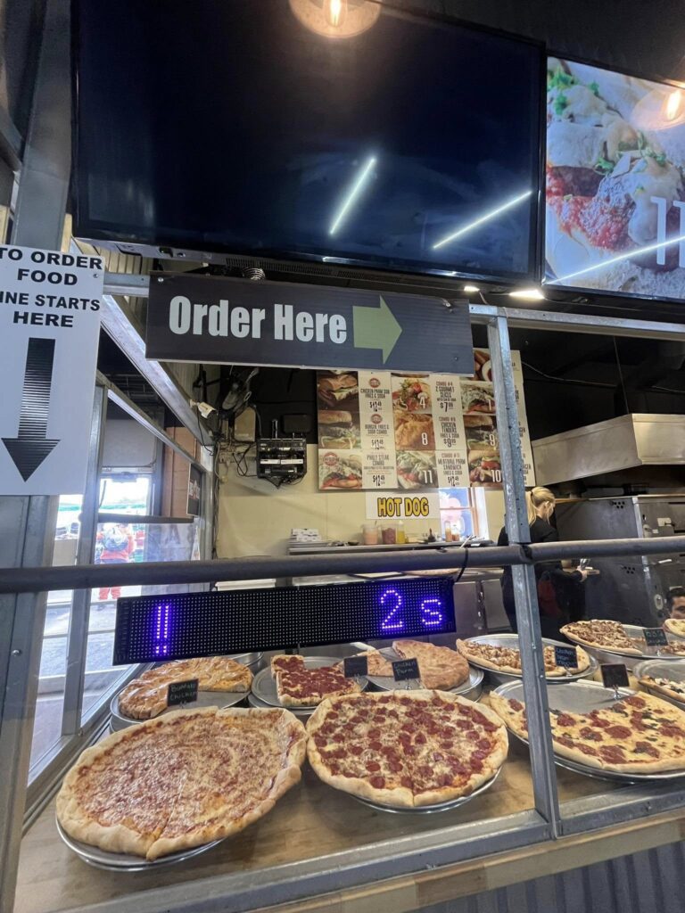 Pizza display case beneath "Order Here" sign