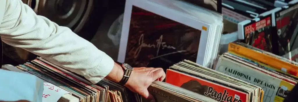 Person's hand browsing vintage vinyl records in store