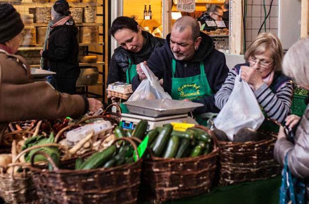 Vendors bagging fresh zucchinis at market