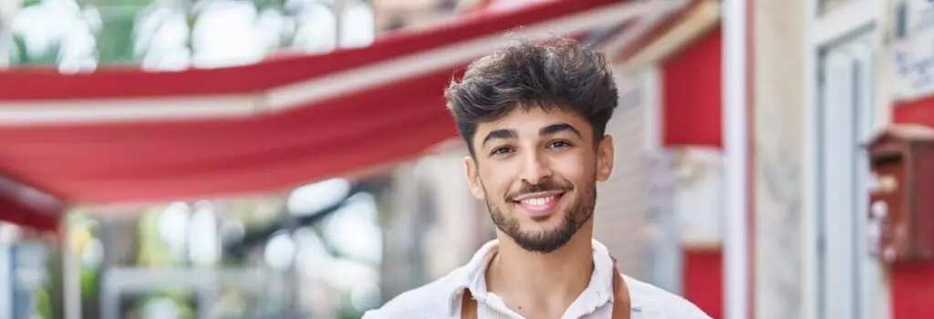 Smiling barista in apron outside cafe